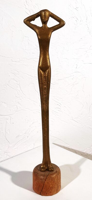 Zelta figūra uz koka statīva